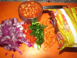 baked beans and chopped vegetables with packs of noodles
